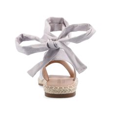 Introducing the Emelie wrap-around sandal by Journee Collection—a stylish fusion of comfort and sophistication. This open-toe sandal features a distinctive wrap-around ankle strap with whipstitch trim and espadrille details, creating a trendy look. Designed for all-day wear, the Emelie sandal comes equipped with a 4 mm Tru Comfort Foam™ Footbed for a cushioned feel, and its flat sole ensures both ease of movement and a laid-back charm. Crafted with faux suede uppers, it exudes a luxurious appear Summer Lace-up Sandals With Wrapped Flat Heel, Adjustable Flat Heel Sandals For Spring, Spring Sandals With Wrapped Flat Heel, Chic Ankle Wrap Sandals For Beach, Cross-tied Ankle Wrap Sandals, Spring Lace-up Sandals With Cushioned Footbed And Flat Heel, Adjustable Ankle-wrap Sandals For Summer, Chic Ankle Wrap Lace-up Sandals For Vacation, Adjustable Sandals With Cushioned Footbed