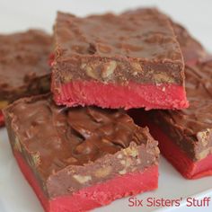 four pieces of chocolate fudge candy on a white plate with red and brown squares