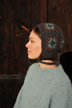 a woman wearing a knitted hat with flowers on it