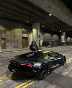 a black sports car parked in an empty parking garage