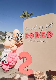 a sign that says rodeo with balloons in the shape of animals and numbers on it