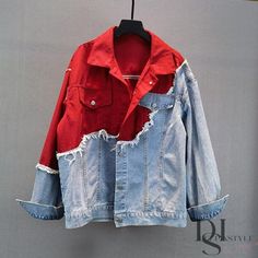 a red and blue jean jacket hanging on a hanger in front of a gray wall