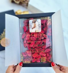 a person holding up a card with roses in it