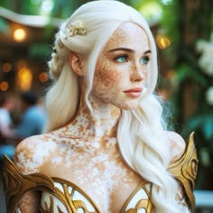 a woman with white hair and freckles on her face is dressed up like a snow queen