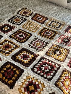 a crocheted blanket is laying on a bed