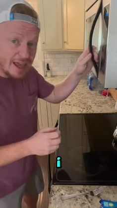 a man is holding up an oven door in front of his face and looking at the camera