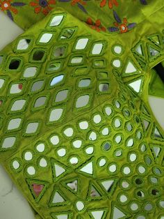 two pieces of green fabric with holes cut out in the middle, on top of each other