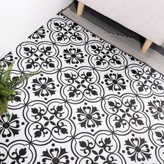 a black and white floor mat next to a plant