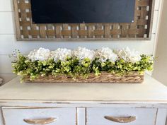 a basket filled with flowers sitting on top of a dresser