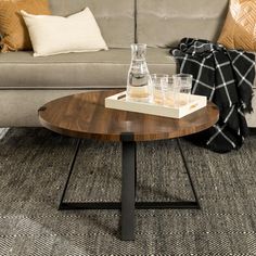 a coffee table with two glasses on it in front of a couch