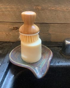 a wooden brush sitting on top of a soap dispenser