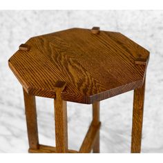 a small wooden table with two legs and a hexagonal shape on the top