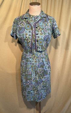 This is a cute vintage dress & bolero from the 50s.  No labels or tags. The bust measures 36", waist 28", hip 38", see measurements below.  Made of a cotton fabric in a turquoise, blue, and olive-green abstract pattern. The dress is sleeveless. It has a round neck and a fitted waist with a single string belt loop. has an olive-green cotton cord belt.  The skirt is straight and has a kick pleat in back. Zips up the back with a long metal zipper. The bolero jacket has short sleeve, a small collar Blue Vintage Dress With Buttons For Vintage Fashion, Retro Vintage Dress With Buttons, Blue Vintage Dress With Buttons, Lined Vintage Dress In Retro Style, Lined Retro Vintage Dress For Vintage Fashion, Blue Fitted Retro Vintage Dress, Retro Dresses With Buttons, Lined Retro Vintage Dress, Blue Retro Dress With Short Sleeves