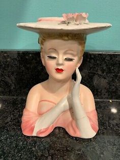 a ceramic figurine with a hat on top of it's head sitting on a counter