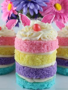 four different colored cakes with bunny ears on top