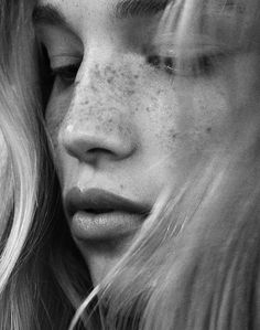 black and white photograph of two women with freckles on their faces looking at each other