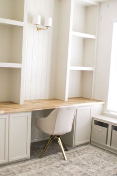 an empty room with white cabinets and a desk