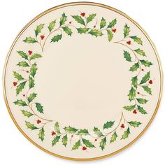 a white plate topped with holly leaves and red berries on the rim, next to a green border