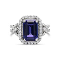 Metal: 14K White Gold Gemstones: 4.85 Cts. Tanzanite 0.65 Cts. Diamond Tanzanite Ring With Radiant Cut Center Stone, Radiant Cut Tanzanite Ring With Center Stone, Emerald Cut Tanzanite Diamond Ring, Tanzanite Gemstone Ring In Baguette Cut, Formal Sapphire Diamond Ring With Gemstone Accents, Elegant Tanzanite Emerald-cut Diamond Ring, Elegant Tanzanite Emerald Cut Diamond Ring, Formal White Gold Sapphire Ring With Gemstone Accents, Formal Cluster Ring With Gemstone Accents