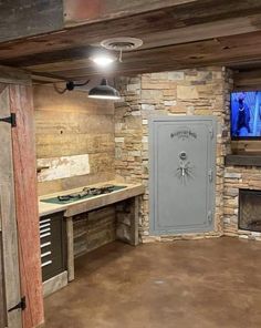 an unfinished basement with stone walls and a television on the wall, built into the ceiling