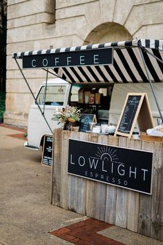 a food truck parked on the side of a road next to a building with a sign that says lowlight espresso