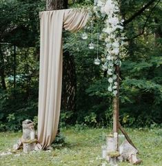 an outdoor wedding ceremony setup with flowers and greenery on the altar, surrounded by trees