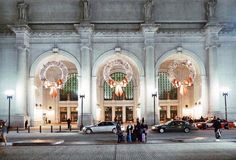 people are standing in front of the entrance to a large building with arches and chandeliers