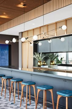 an empty bar with stools in front of it and lights hanging from the ceiling