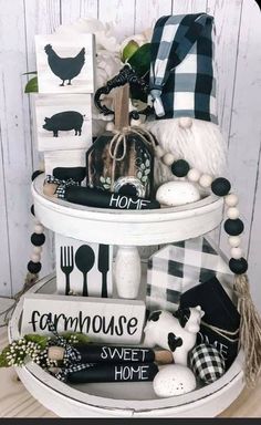 a three tiered display with farm themed items on it's sides and black and white decor