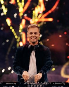 a man standing in front of a sound board with fireworks coming out of the sky behind him