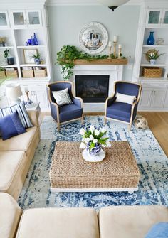 a living room with couches, chairs and a fire place in the center area