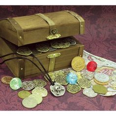 a wooden chest with several different types of coins in it and a leather cord on the ground