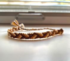 a brown and white bracelet sitting on top of a window sill