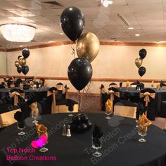 black and gold balloons are on top of the tables