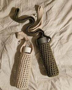 two crocheted water bottles on a bed