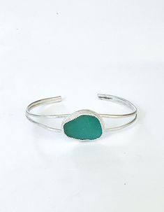 Sea glass jewelry This sea glass bracelet is bold yet elegant.  The color of the sea glass is so beautiful!  It emits the soothing calm and peace of the sea.  What a perfect keepsake of the sea for a beach lover.  It would also be a stunning handmade gift for wife. The genuine sea glass is nestled in a Bezel setting of fine silver and placed on a handcrafted sterling silver cuff.  The best features of this sea glass bracelet are that it is easy to put on and take off and it will fit most wrists Sea Glass Bracelet, Silver Sea, Silver Gift Box, Beach Lover, Glass Bracelet, Bracelet Sterling Silver, Sea Glass Jewelry, Sterling Silver Cuff, Gift For Wife