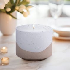 a white candle sitting on top of a table