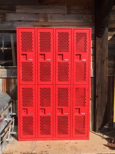 a large red metal locker sitting next to a building