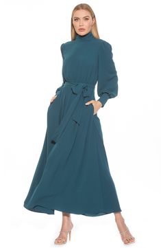 The Saliah mockneck blouson sleeve maxi dress is a classic staple piece for your wardrobe. This maxi dress features mockneck with shirring detail, dramatic blouson sleeves, elastic waist with waistband, and full maxi skirt. 55.5" length (size 4) Mock neck Back closure Long blouson sleeves Allover floral print Lined 97% polyester, 3% spandex Machine wash Imported Model stats: 5'10" height, 32" bust, 25" waist, 36" hip. Model is wearing size 4 Modest Long Sleeve Maxi Dress For Work, Elegant Maxi Dress With Bishop Sleeves For Fall, Fall Maxi Dress With Modesty Panel, Modest Maxi Dress For Formal Fall Occasions, Modest Maxi Dress For Formal Fall Events, Modest Midi Dress With Elastic Sleeves, Modest Formal Fall Maxi Dress, Modest Formal Maxi Dress For Fall, Modest Midi Dress With Gathered Sleeves