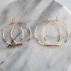 Have you ever seen a rainbow in the sky and just thought, 'meh'? Yeah, we didn't think so! These lightweight hoop earrings with tiny beads in a rainbow pattern will give you that just-spotted-a-rainbow feeling! + style name: RAINBOW + beaded hoops with ivory, red, orange, yellow, green, blue and purple Delica beads+ gold-plated stainless steel ear wire hooks and beading wire (lead-free and nickle-free)+ comes with plastic earring back for security+ available in two large sizes: BIG, a teardrop s Rainbow Beaded Bohemian Hoop Earrings, Bohemian Rainbow Beaded Hoop Earrings, Bohemian Beaded Rainbow Hoop Earrings, Nickel-free Round Rainbow Beaded Earrings, Bohemian Rainbow Dangle Hoop Earrings, Rainbow Beaded Dangle Hoop Earrings, Rainbow Dangle Hoop Earrings, Small Hoop Rainbow Beaded Earrings In Bohemian Style, Rainbow Dangle Jewelry With Tiny Beads