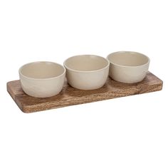 three white bowls are sitting on a wooden tray