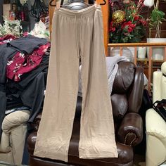 a pair of pants sitting on top of a leather chair in front of a pile of clothes