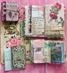 an assortment of scrapbook pages are displayed on a pink wooden surface with flowers and lace