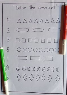 two markers are sitting on top of a sheet of paper with numbers and shapes drawn