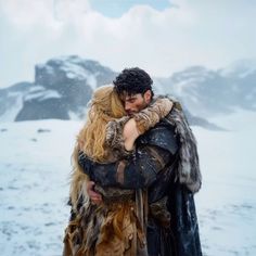 a man and woman hugging in the snow