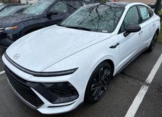 a white car parked in a parking lot next to other cars