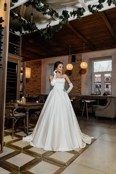 a woman in a white wedding dress posing for the camera