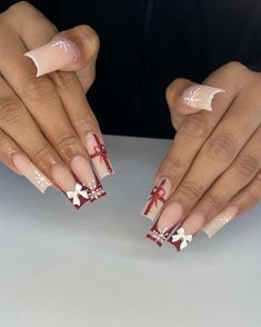 Featuring a neutral matte base, these nails are adorned with festive red ribbons and 3D white bows, giving the look of beautifully wrapped Christmas presents. Delicate white snowflakes add a wintery touch, while the deep red French tips create a bold, festive accent that’s both playful and elegant. Christmas Nails With Bow Charm, Nails With Bows Christmas, Red French Tip Nails With Snowflakes, Snowflake French Tips, Christmas Nails Stilleto Shape, Deep Red French Tip, Red French Christmas Nails, White And Red Christmas Nails, Christmas Nails Present