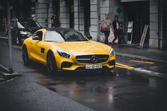 a yellow mercedes sports car is parked on the street