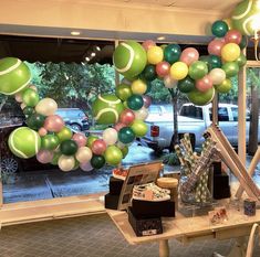 a table with balloons and other items on it in front of a storefront window